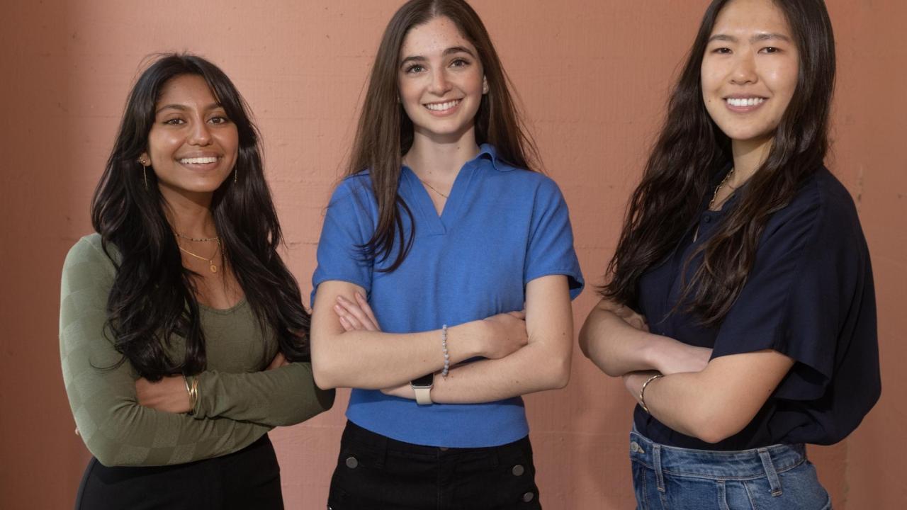 All three Goldwater Scholars posing for a picture in front of a plain salmon colored wall.