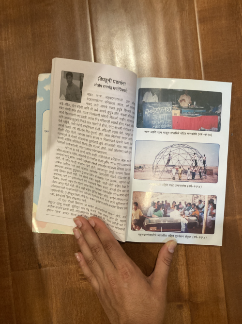 A book of stories open on a plain wood table, to a page with text on one side and three pictures on the other.