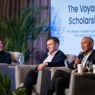 Former President Barack Obama alongside Airbnb Co-Founder and CEO, Brian Chesky and a panel moderator sit in chairs in front of a PPT titled The Voyager Scholarship.
